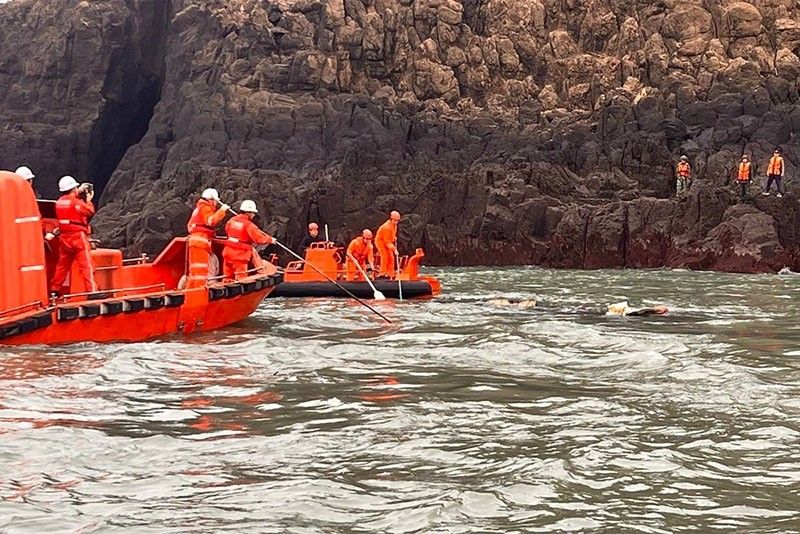 This handout picture released by Taiwan’s Coast Guard shows Chinese Coast Guard personnel (white helmets) and members of Taiwan's Coast Guard (orange helmets) taking part in a joint search-and-rescue mission after a Chinese fishing boat capsized in waters near Kinmen Islands' Dongding islet.