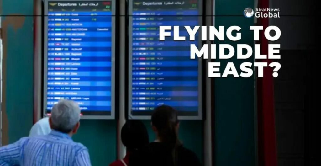 Passengers checking a screen at an airport