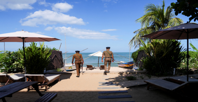 Policemen guard the beachside tourist hotel in Arugam Bay in Sri Lanka