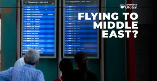 Passengers checking a display screen at an airport