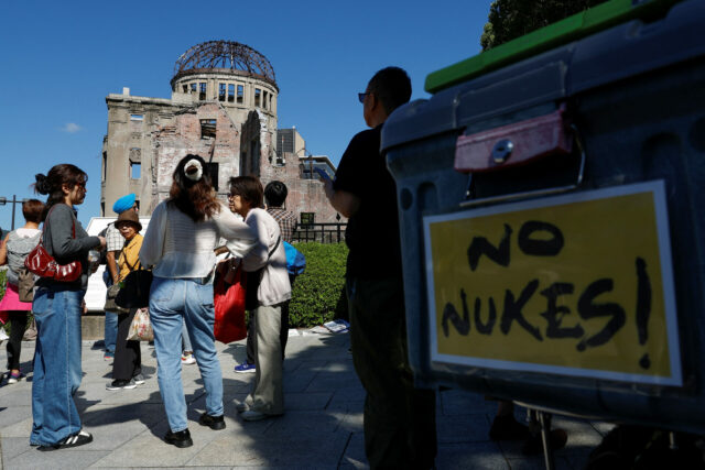 Visitors standing near the gutted Atomic Bomb dome in Hiroshima
