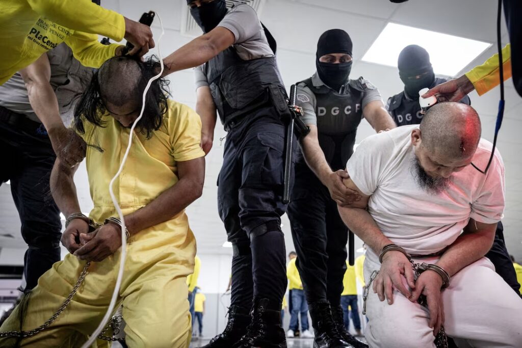 Salvadoran police officers cut the hair of alleged members of the Venezuelan gang Tren de Aragua recently deported by the U.S. government to be imprisoned in the Terrorism Confinement Center (CECOT) prison, as part of an agreement with the Salvadoran government, in Tecoluca, El Salvador, in this handout image obtained March 16, 2025. Secretaria de Prensa de la Presidencia/Handout via REUTERS