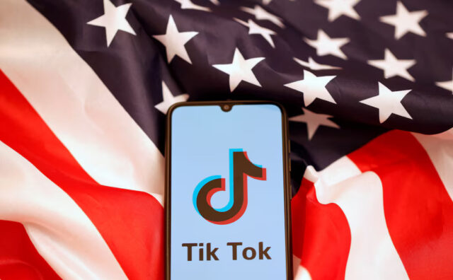 Tik Tok logo is displayed on the smartphone while standing on the U.S. flag in this illustration picture taken, November 8, 2019. REUTERS/Dado Ruvic/File Photo
