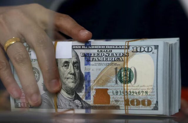 QSYIRBVPAVMQFLYQRHHCVIWYOE An employee of a money changer holds a stack of U.S. Dollar notes before giving it to a customer in Jakarta, October 8, 2015. REUTERS/Beawiharta/File Photo