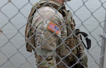 An Army National Guard soldier stands outside of a gate at the US-Mexico border in Eagle Pass, Texas, U.S., February 7, 2025. REUTERS/Kaylee Greenlee Beal/File Photo