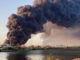 A view shows a large plume of smoke rising from fuel depot in Port Sudan, Sudan. REUTERS/Khalid Abdelaziz