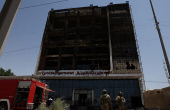A fire truck stands next to the wreckage of a five-storey shopping center, after a massive overnight fire killed dozens of people, in al-Kut, Wasit province, Iraq, July 17, 2025. REUTERS/Ahmed Saad