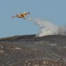 An aircraft makes a water drop over an area burned by a wildfire in the Atlanterra area in Tarifa, Spain, August 12, 2025. REUTERS/Marcelo Del Pozo