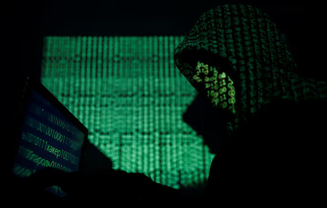 DTU77PAQLRJGRJMMVZQ6D5WFP4 A hooded man holds a laptop computer as cyber code is projected on him in this illustration picture taken on May 13, 2017. REUTERS/Kacper Pempel/Illustration/FIle Photo
