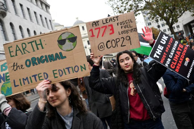 3TADCU3WXBPRDBACEAZQ3VLXCA People hold placards during a protest against the United Nations Climate Change Conference (COP29) in Baku, in London, Britain, November 16, 2024. REUTERS/Chris J. Ratcliffe/File Photo