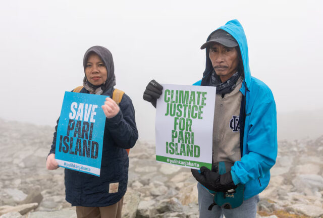 GKI2FYM2P5I4PI5YEF2X556JWI Ibu Asmania and Arif Pujianto, residents of Indonesia's Pulau Pari Island, hold placards on Eggishorn mountain, near the mist-covered Aletsch glacier, before a Swiss court's expected decision whether to accept a legal complaint filed by Indonesian residents against major cement manufacturer Holcim, headquartered in Switzerland, which they say is doing "too little" to cut carbon emissions, in Fiesch, Switzerland, August 30, 2025. REUTERS/Denis Balibouse