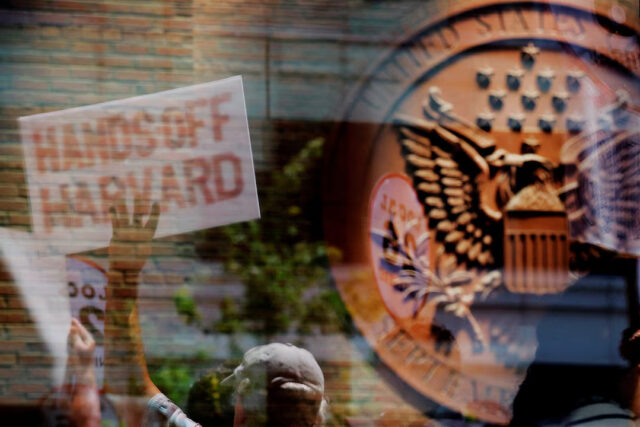 GYCJWH4JLZJWZAPMLQYS24CVQE Demonstrators with group Crimson Courage, who gathered to support Harvard University outside a hearing before a federal judge to order U.S. President Donald Trump's administration to restore about $2.5 billion in canceled federal grants and cease efforts to cut off research funding, are reflected in a window of the federal courthouse in Boston, Massachusetts, U.S., July 21, 2025. REUTERS/Brian Snyder/File Photo