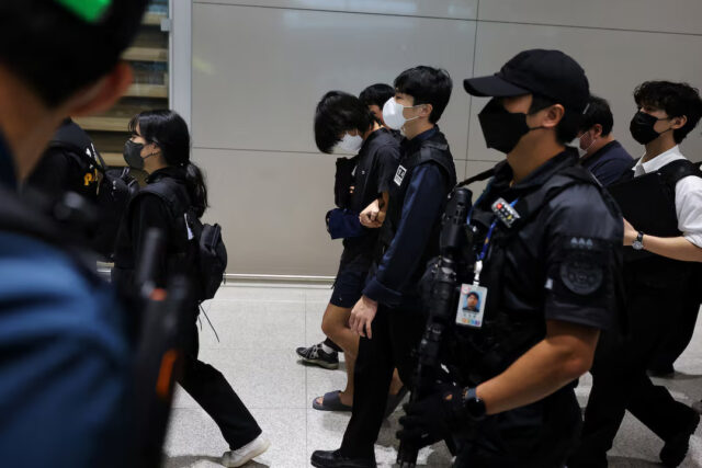 4L7B5Z6K6RMQVHKRLCR3RR3P7M Police officers escort South Korean deportees suspected of being involved in online scam operations in Cambodia, upon their arrival at the Incheon International Airport in Incheon, South Korea, October 18, 2025. REUTERS/Kim Hong-Ji