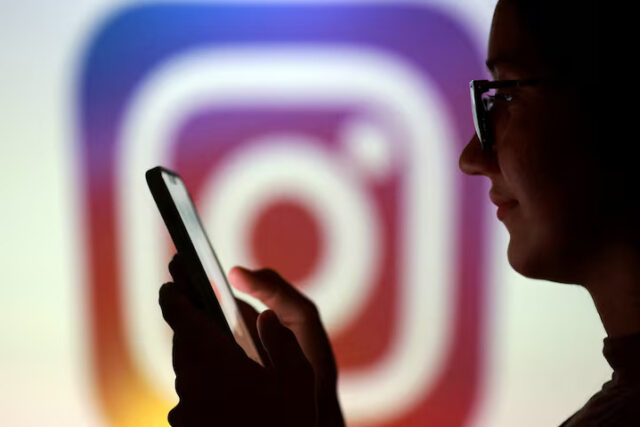 KCYYTMJZBBP45GJZXOQY6FCNWI A teenager poses for a photo while holding a smartphone in front of a Instagram logo in this illustration taken September 11, 2025. REUTERS/Dado Ruvic/Illustration/File Photo