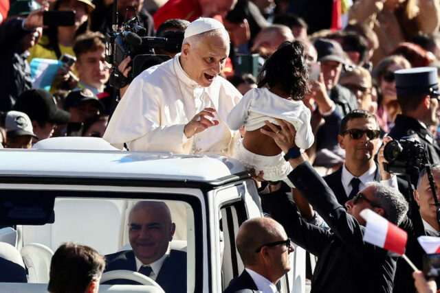 UHFDMMUZ7RJTTCW5DZOKT734XI Pope Leo XIV reacts next to a child as he arrives for a general audience in St. Peter's Square at the Vatican, October 8, 2025. REUTERS/Yara Nardi/File Photo
