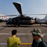 People stand near a Z-20 helicopter displayed at the China International Aviation and Aerospace Exhibition, or Airshow China, in Zhuhai, Guangdong province, China November 12, 2024. REUTERS/Tingshu Wang