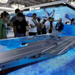 Visitors look at a model of the Fujian Type 003 aircraft carrier displayed at the China International Aviation and Aerospace Exhibition, or Airshow China, in Zhuhai, Guangdong province, China November 14, 2024. REUTERS/Tingshu Wang