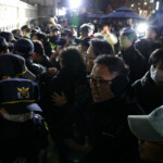 People react as police close the gate of the National Assembly, after South Korean President Yoon Suk Yeol declared martial law, in Seoul, South Korea, December 4, 2024. REUTERS/Kim Hong-Ji