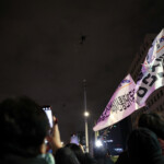 People wave banners as military helicopters fly, after South Korean President Yoon Suk Yeol declared martial law, in Seoul, South Korea, December 4, 2024. REUTERS/Kim Hong-Ji