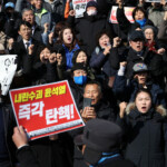 People hold signs during a rally calling for the resignation of South Korean President Yoon Suk Yeol, in Seoul, South Korea, December 4, 2024. REUTERS/Kim Hong-Ji