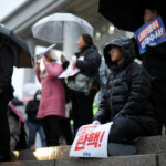 People hold signs during a candlelight vigil to demand the resignation of South Korean President Yoon Suk Yeol, who declared martial law which was reversed hours later, at the National Assembly in Seoul, South Korea, December 5, 2024. REUTERS/Kim Hong-ji
