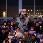 People hold candles and signs during a candlelight vigil to demand the resignation of South Korean President Yoon Suk Yeol, who declared martial law which was reversed hours later, at the National Assembly in Seoul, South Korea, December 5, 2024. REUTERS/Kim Hong-ji