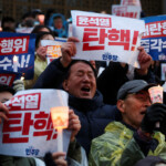 People hold candles and signs during a candlelight vigil to demand the resignation of South Korean President Yoon Suk Yeol, who declared martial law which was reversed hours later, at the National Assembly in Seoul, South Korea, December 5, 2024. REUTERS/Kim Hong-ji TPX IMAGES OF THE DAY
