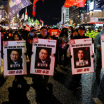 Protesters hold placards during a candlelight vigil to condemn South Korean President Yoon Suk Yeol's surprise declarations of the failed martial law and to call for his resignation in Seoul, South Korea, December 5, 2024. REUTERS/Kim Kyung-Hoon