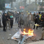 Rebel fighters gather around a fire lit in materials in Homs after Syria's army command notified officers on Sunday that President Bashar al-Assad's 24-year authoritarian rule has ended, a Syrian officer who was informed of the move told Reuters, following a rapid rebel offensive, in Homs, Syria December 8, 2024. REUTERS/Mahmoud Hasano