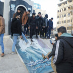 People kick a poster depicting Syrian President Bashar al Assad after Syria's army command notified officers on Sunday that President Bashar al-Assad's 24-year authoritarian rule has ended, a Syrian officer who was informed of the move told Reuters, following a rapid rebel offensive, in Homs, Syria December 8, 2024. REUTERS/Mahmoud Hasano