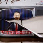 A person passes by placards with images of South Korean President Yoon Suk Yeol on the day of a rally calling for the impeachment of South Korean President Yoon Suk Yeol, who declared martial law, which was reversed hours later, near the National Assembly, in Seoul, South Korea, December 9, 2024. REUTERS/Kim Kyung-Hoon