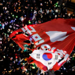 Protesters tear a banner representing the flag of the ruling People Power Party as they attend a rally calling for the impeachment of South Korean President Yoon Suk Yeol, who declared martial law, which was reversed hours later, in front of the headquarters of the ruling People Power Party, in Seoul, South Korea, December 9, 2024. REUTERS/Kim Kyung-Hoon