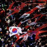 Protesters tear a banner representing the flag of the ruling People Power Party as they attend a rally calling for the impeachment of South Korean President Yoon Suk Yeol, who declared martial law, which was reversed hours later, in front of the headquarters of the ruling People Power Party, in Seoul, South Korea, December 9, 2024. REUTERS/Kim Kyung-Hoon