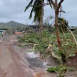 People walk on a damaged road, in the aftermath of the Cyclone Chido, in Mayotte, France, in this screengrab from a video obtained from social media, December 15, 2024. GENDARMERIE NATIONALE/via REUTERS