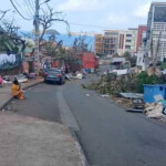 A person sits on the curb in the aftermath of Cyclone Chido, in Mamoudzou, Mayotte, France, December 15, 2024, in this screen grab obtained from video. John Balloz/via REUTERS