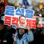 Protesters hold signs that read, "Arrest Yoon Suk Yeol immediately," during a rally against the impeached South Korean President Yoon Suk Yeol near his official residence, after investigators were unable to execute an arrest warrant on Friday for Yoon, according to the Corruption Investigation Office for High-ranking Officials, in Seoul, South Korea, January 3, 2025. REUTERS/Kim Hong-Ji