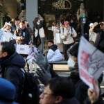 Tourists look on as anti-Yoon protesters march towards impeached South Korean President Yoon Suk Yeol's official residence, after investigators were unable to execute an arrest warrant on Friday for Yoon according to the Corruption Investigation Office for High-ranking Officials, in Seoul, South Korea, January 3, 2025. REUTERS/Kim Hong-Ji