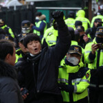Police officers detain a man who jumped over a fence during a Pro-Yoon protest rally outside a court on the day South Korea's impeached President Yoon Suk Yeol plans to attend a court hearing to fight a request by investigators to extend his detention on accusations of insurrection, in Seoul, South Korea, January 18, 2025. REUTERS/Kim Hong-Ji