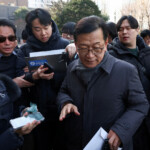 Seok Dong-hyeon, a lawyer for South Korea's impeached President Yoon Suk Yeol, is surrounded by media upon his arrival at a court as Yoon plans to attend a court hearing to fight a request by investigators to extend his detention on accusations of insurrection, in Seoul, South Korea, January 18, 2025. REUTERS/Kim Hong-Ji/Pool