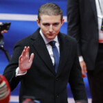 Barron Trump waves as he arrives at Capital One arena on the inauguration day of Donald Trump's second presidential term, in Washington, U.S., January 20, 2025. REUTERS/Brian Snyder