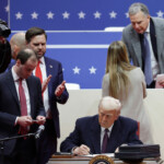 U.S. President Donald Trump signs executive orders during a rally on the inauguration day of his second Presidential term, inside Capital One, in Washington, U.S. January 20, 2025. REUTERS/Mike Segar