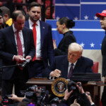 U.S. President Donald Trump signs an executive order in front of supporters inside the Capital One Arena as U.S. Vice President J.D. Vance looks on during ceremonies on the inauguration day of his second presidential term, in Washington, U.S. January 20, 2025. REUTERS/Amanda Perobelli