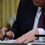 U.S. President Donald Trump signs documents as he issues executive orders and pardons for January 6 defendants in the Oval Office at the White House on Inauguration Day in Washington, U.S., January 20, 2025. REUTERS/Carlos Barria