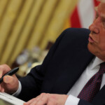 U.S. President Donald Trump signs documents as he issues executive orders and pardons for January 6 defendants in the Oval Office at the White House on Inauguration Day in Washington, U.S., January 20, 2025. REUTERS/Carlos Barria