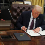 U.S. President Donald Trump signs documents as he issues executive orders and pardons for January 6 defendants in the Oval Office at the White House on Inauguration Day in Washington, U.S., January 20, 2025. REUTERS/Carlos Barria