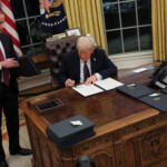 U.S. President Donald Trump signs documents as he issues executive orders and pardons for January 6 defendants in the Oval Office at the White House on Inauguration Day in Washington, U.S., January 20, 2025. REUTERS/Carlos Barria Trump orders