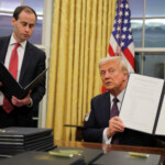 U.S. President Donald Trump signs pardons for January 6 defendants in the Oval Office at the White House on Inauguration Day in Washington, U.S., January 20, 2025. REUTERS/Carlos Barria REFILE - QUALITY REPEAT TPX IMAGES OF THE DAY President Donald Trump
