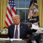 U.S. President Donald Trump holds former United States President Joe Biden's letter on the day he signs documents as he issues executive orders and pardons for January 6 defendants in the Oval Office at the White House on Inauguration Day in Washington, U.S., January 20, 2025. REUTERS/Carlos Barria