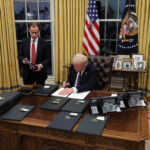 U.S. President Donald Trump signs documents as he issues executive orders and pardons for January 6 defendants in the Oval Office at the White House on Inauguration Day in Washington, U.S., January 20, 2025. REUTERS/Carlos Barria