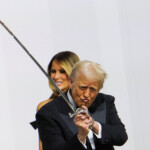U.S. President Donald Trump gestures while holding a sword, near first lady Melania Trump, as they attend the Commander in Chief Ball in honor of his inauguration in Washington, U.S., January 20, 2025. REUTERS/Daniel Cole